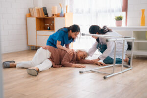 NDIS workers first aid - caregiver support senior elderly patient who having accident to fall on the floor at home, health insurance for emergency help, woman nurse having care injury to disease pain of old Asian people