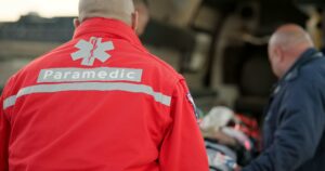 People, uniform and paramedics with emergency, service and patient with injury, victim and teamwork. international paramedics day
